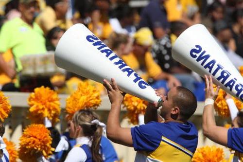 male cheerleader using a "spartan" megaph一个 at football game