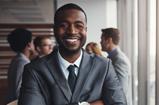 A smiling black man dressed in a professional suit.