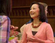 A woman smiling and gesturing with her hands.