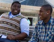 Two students in conversation while smiling.