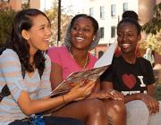 Three students smiling while in conversation.